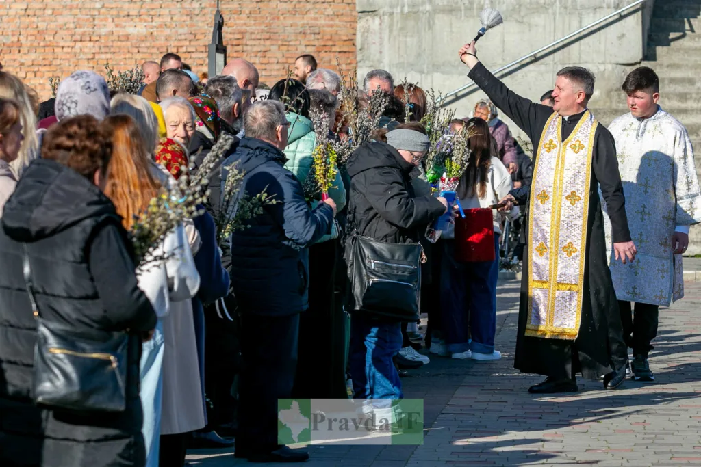Священник освячує вербові гілки на вулиці