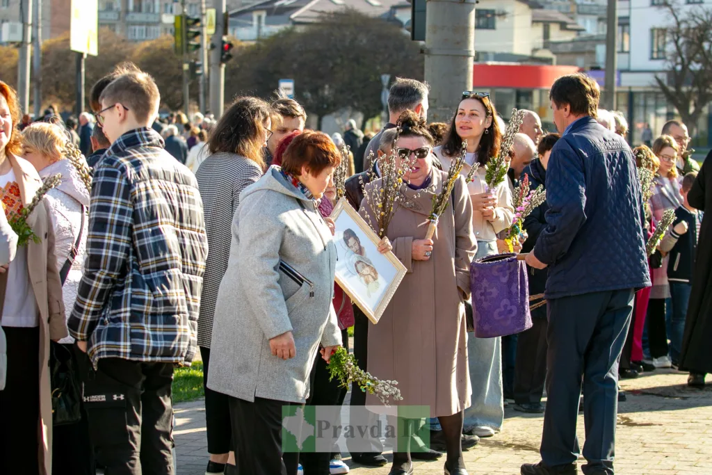 Люди з вербовими гілками на міській вулиці