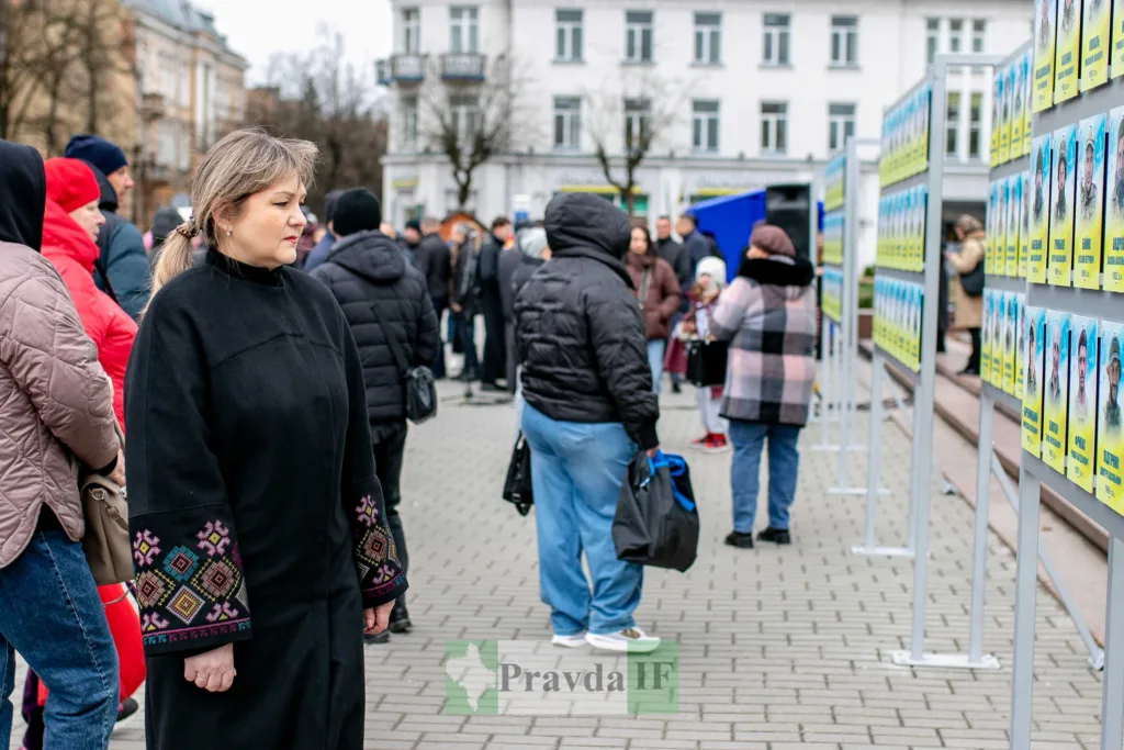 Люди розглядають стенди з фотографіями на вулиці