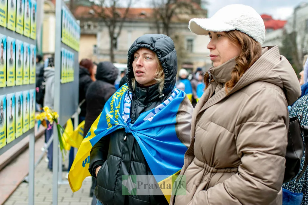 Жінки дивляться на стіну пам'яті захисників України
