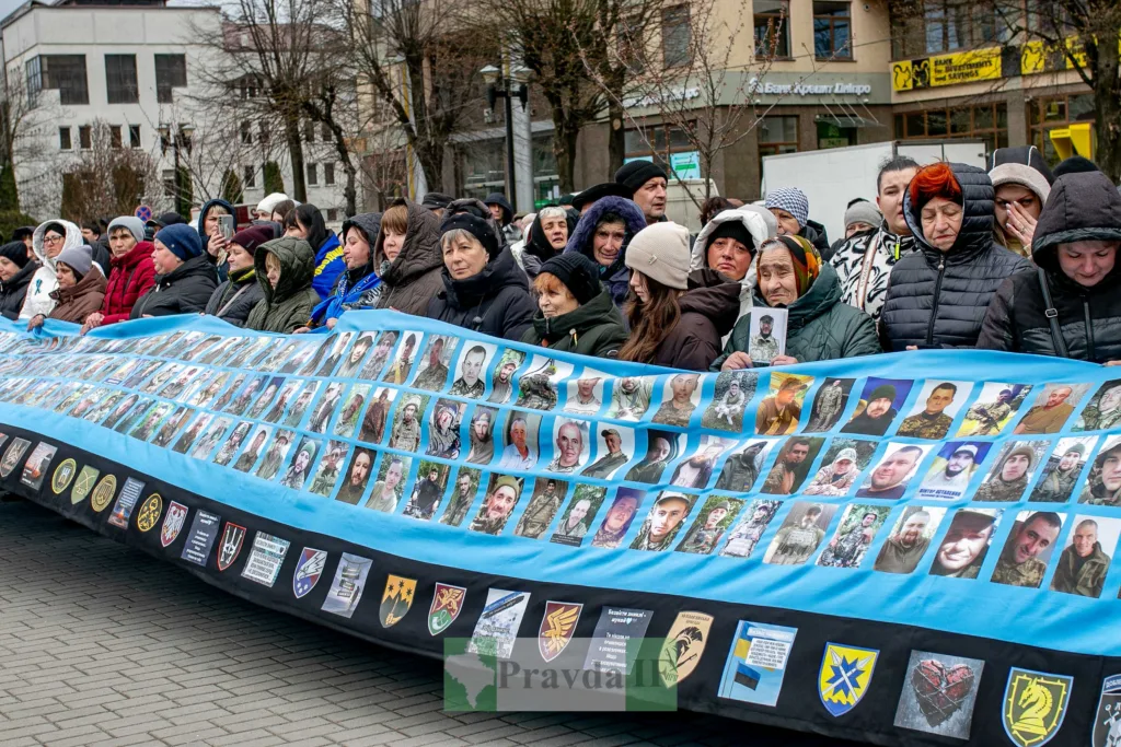 Люди тримають банер із фото зниклих військових України