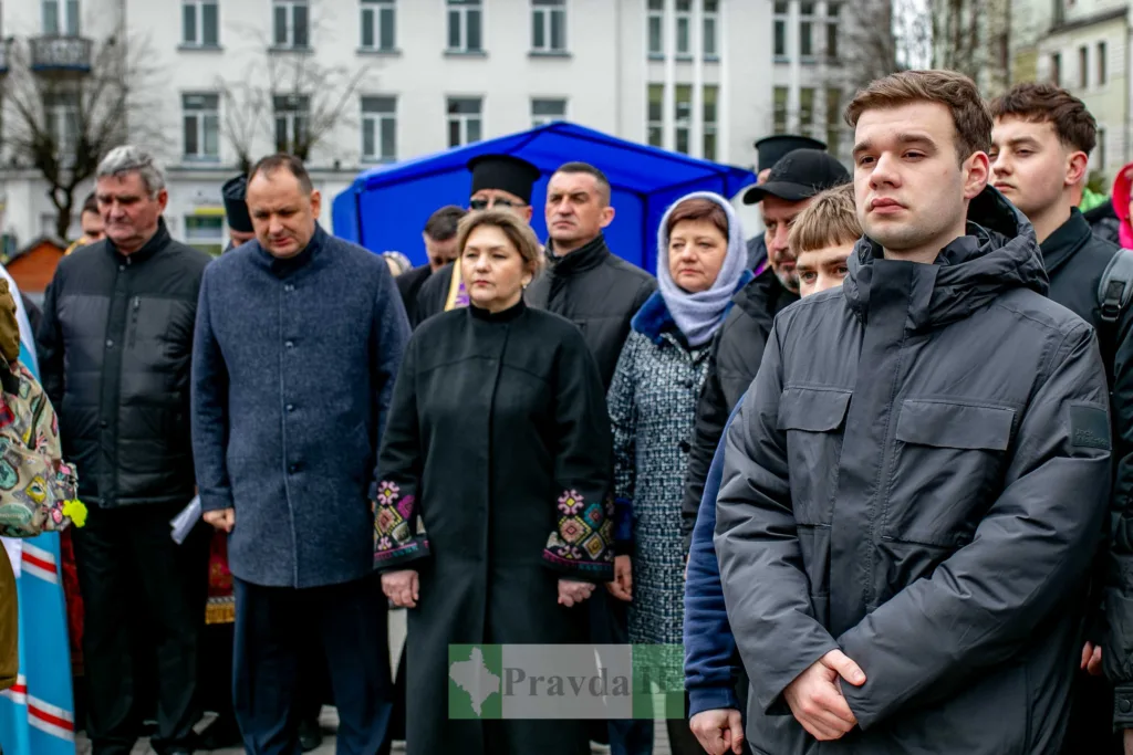 Люди стоять на вуличному заході у місті