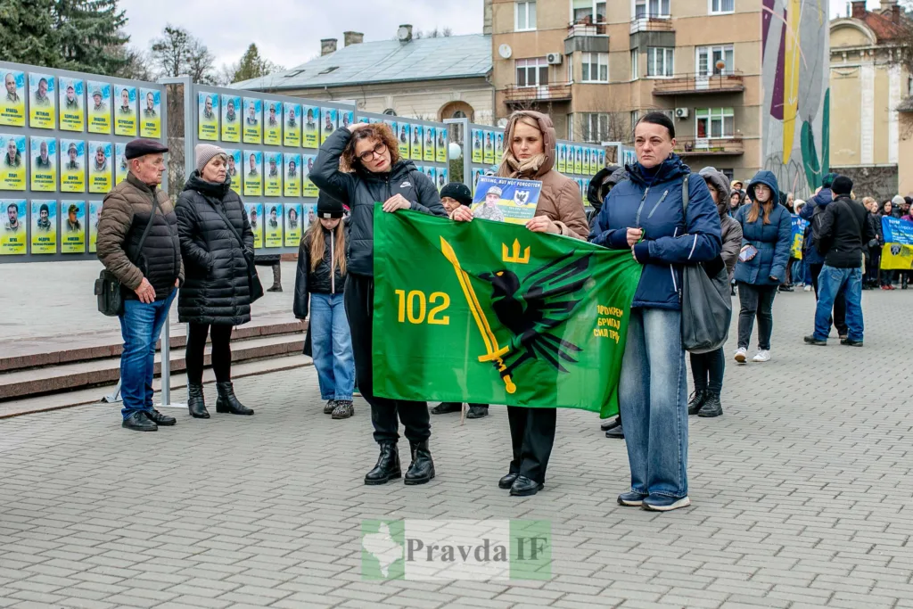 Люди тримають прапор 102 бригади у місті