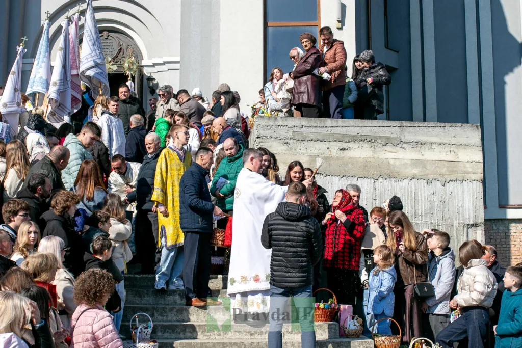 Священник освячує великодні кошики біля церкви