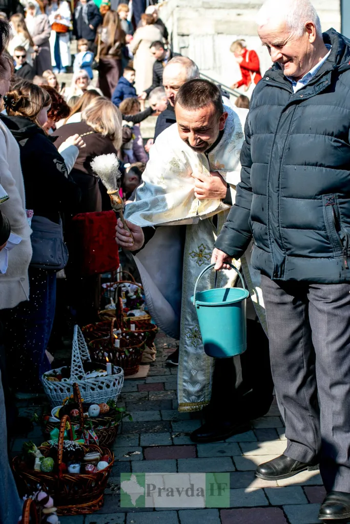 Священник освячує великодні кошики на вулиці