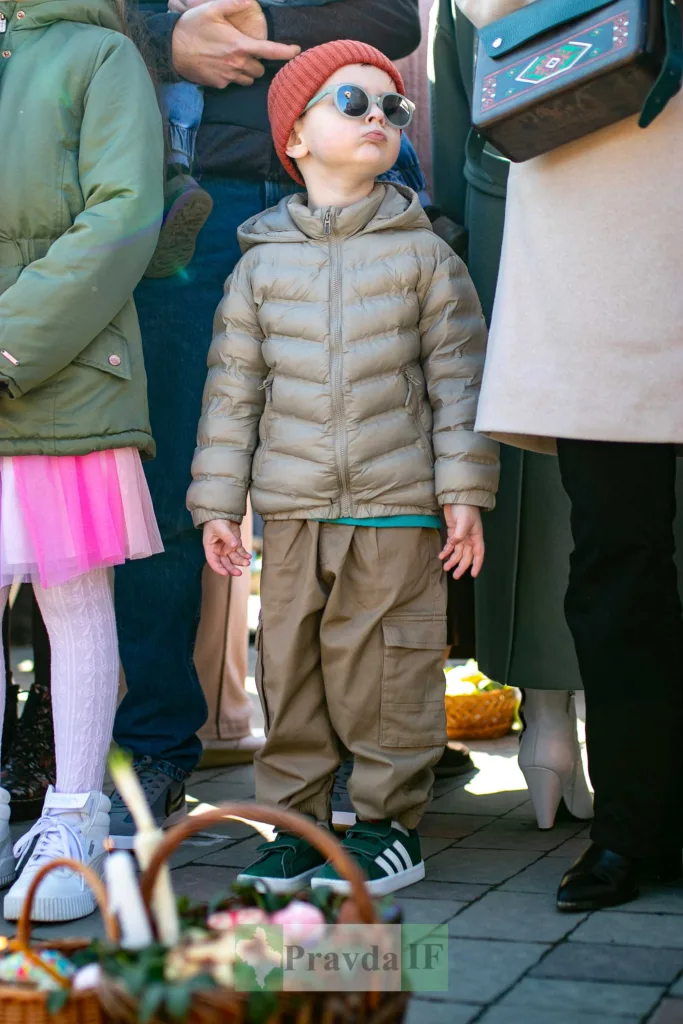 Дитина у сонцях і куртці на вулиці