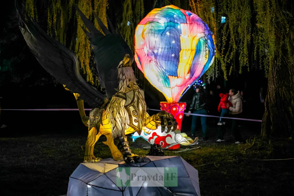 Світлова скульптура грифона та яскравої кулі в парку