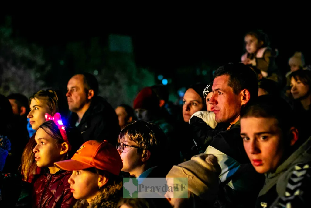 Люди спостерігають виступ на нічному заході