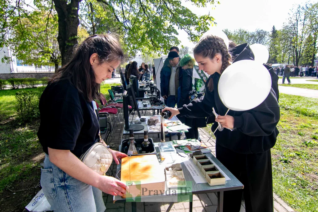 Студентки досліджують зразки на науковому ярмарку просто неба