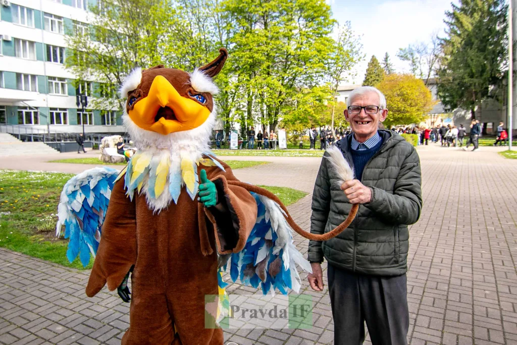 Чоловік поруч із маскотом грифона на вулиці