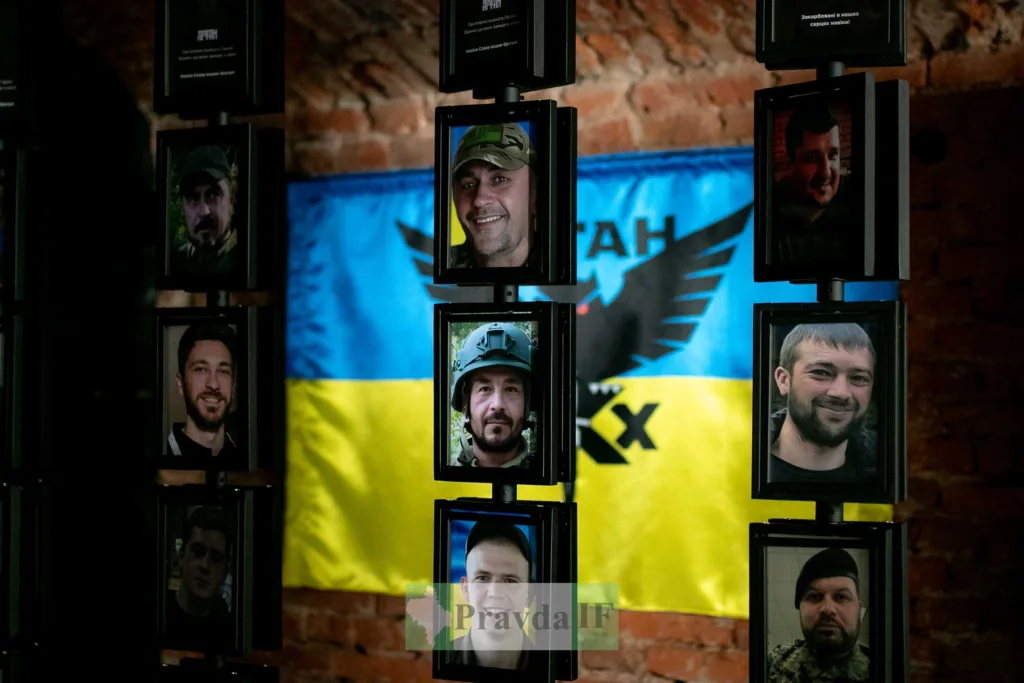 Портрети героїв перед українським прапором