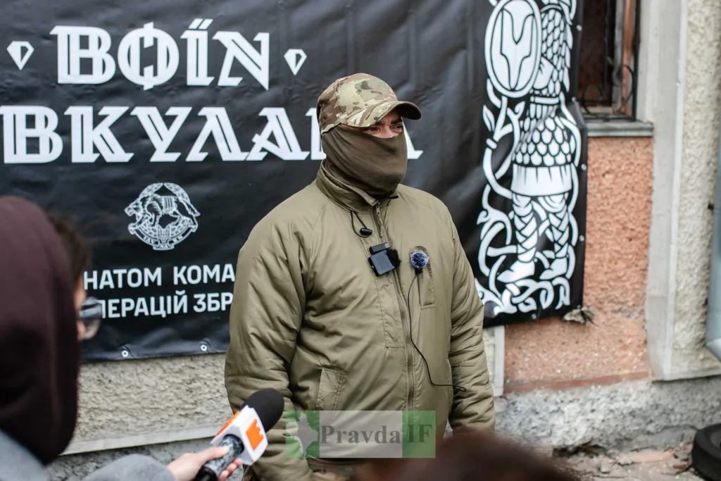 Військовий дає інтерв'ю перед банером