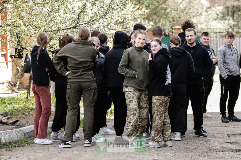 Молодь у камуфляжі стоїть разом на вулиці