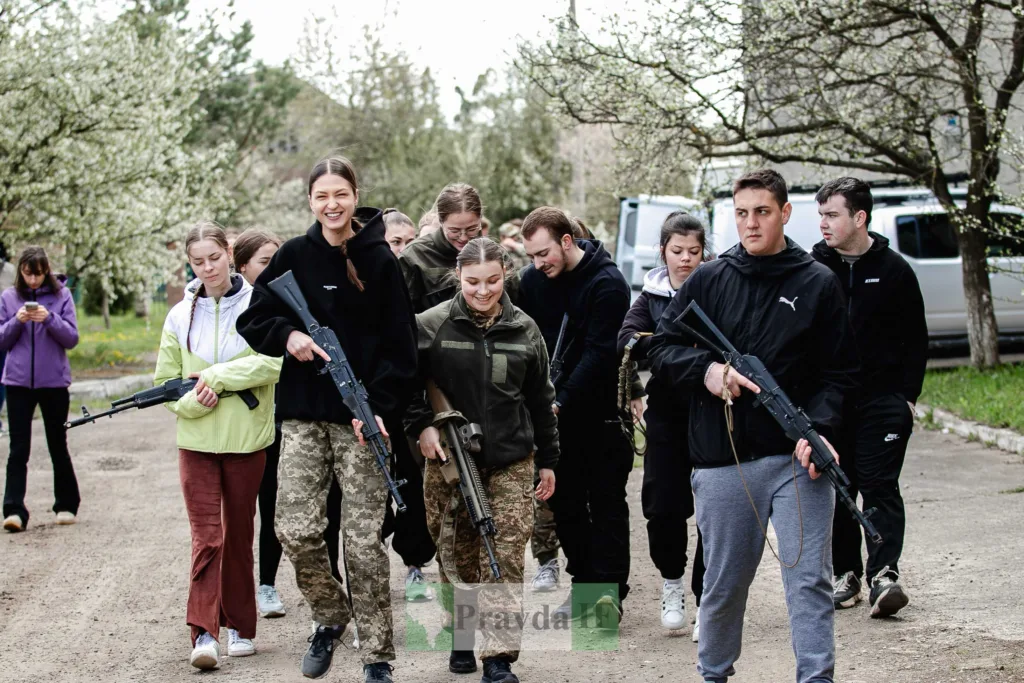 Молоді люди з навчальною зброєю на тренуванні