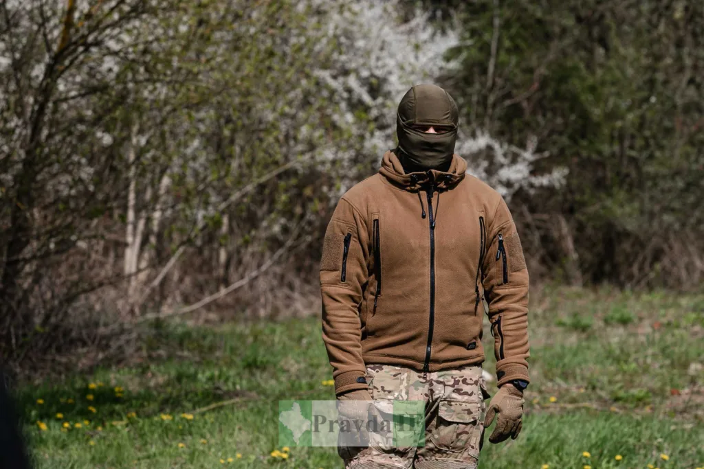 Військовий у камуфляжі стоїть на природі