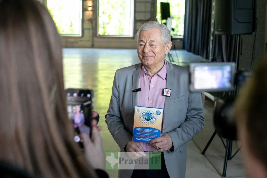 Чоловік дає інтерв'ю, тримаючи рекламну брошуру