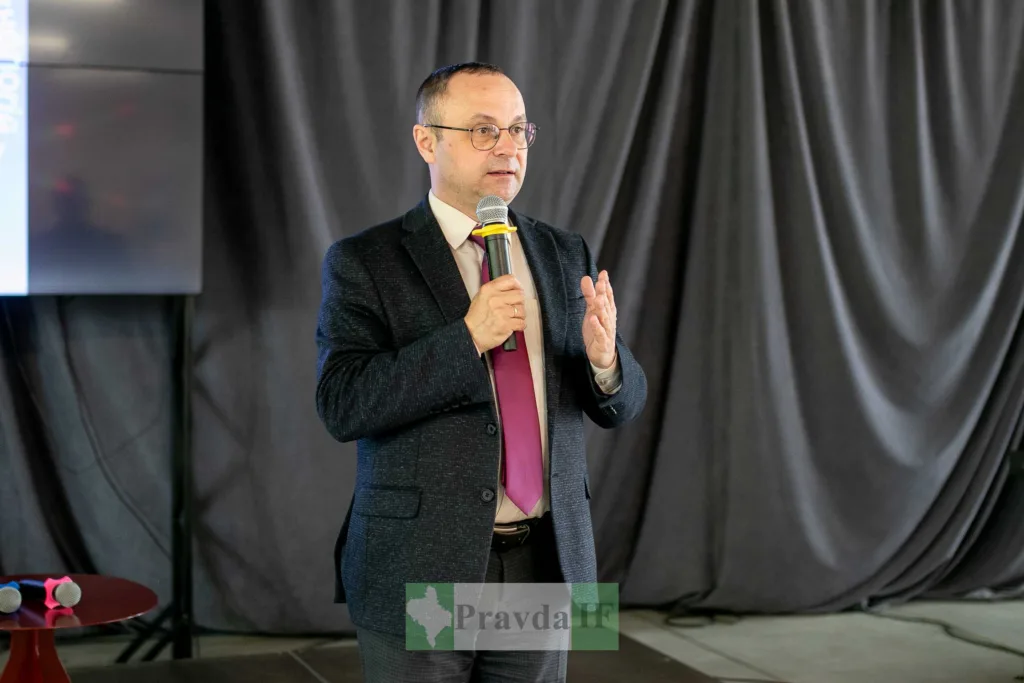 Чоловік виступає з мікрофоном на сцені