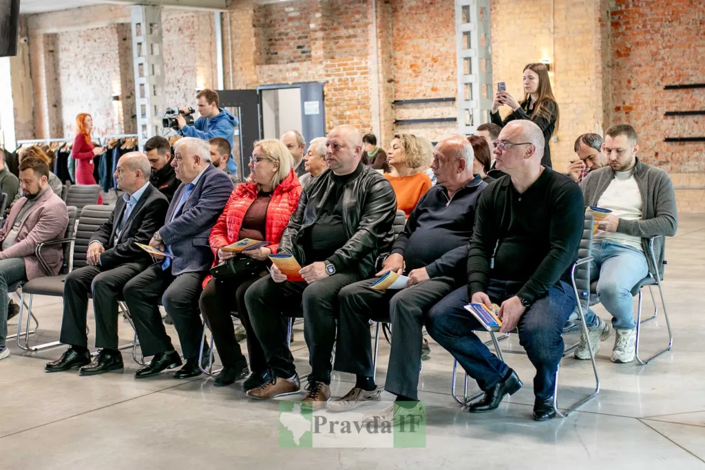 Люди на конференції в сучасній залі