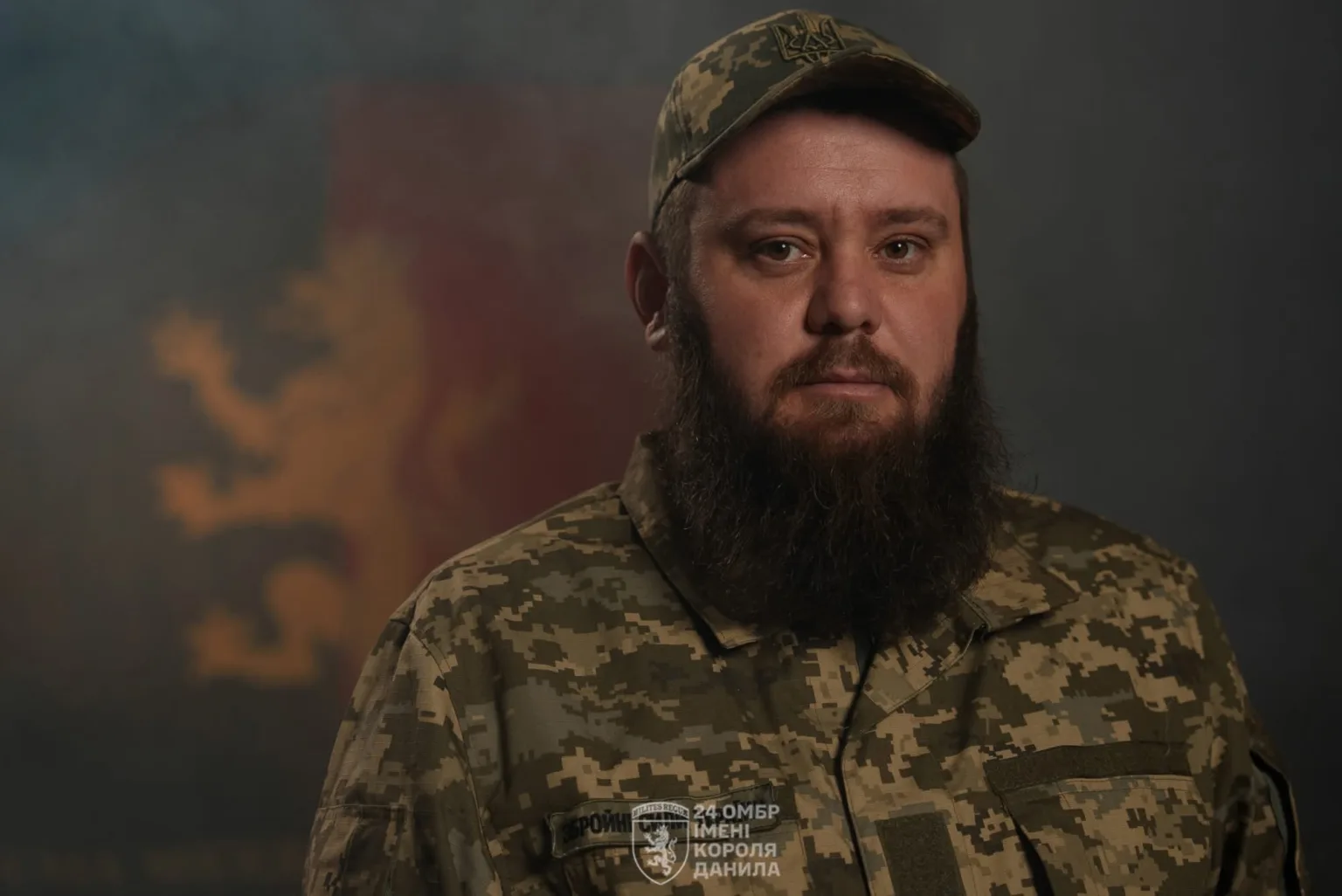 Український військовий у камуфляжі на темному тлі