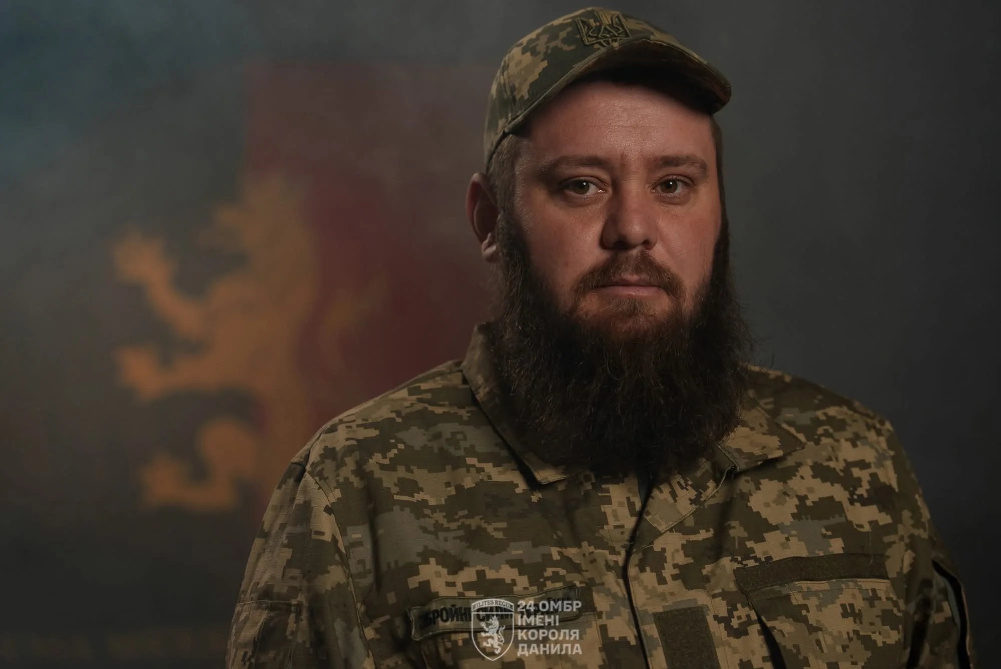 Український військовий у камуфляжі на темному тлі