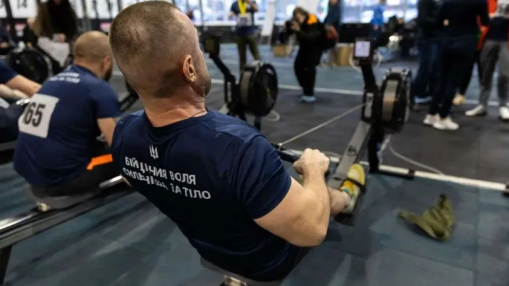 Чоловік тренується на гребному тренажері у спортзалі