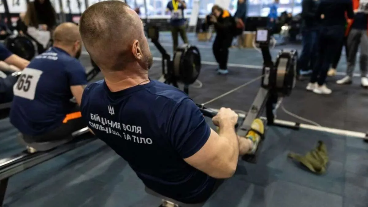 Чоловік тренується на гребному тренажері у спортзалі