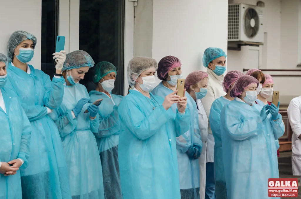 Медичний персонал у захисному одязі фотографує подію