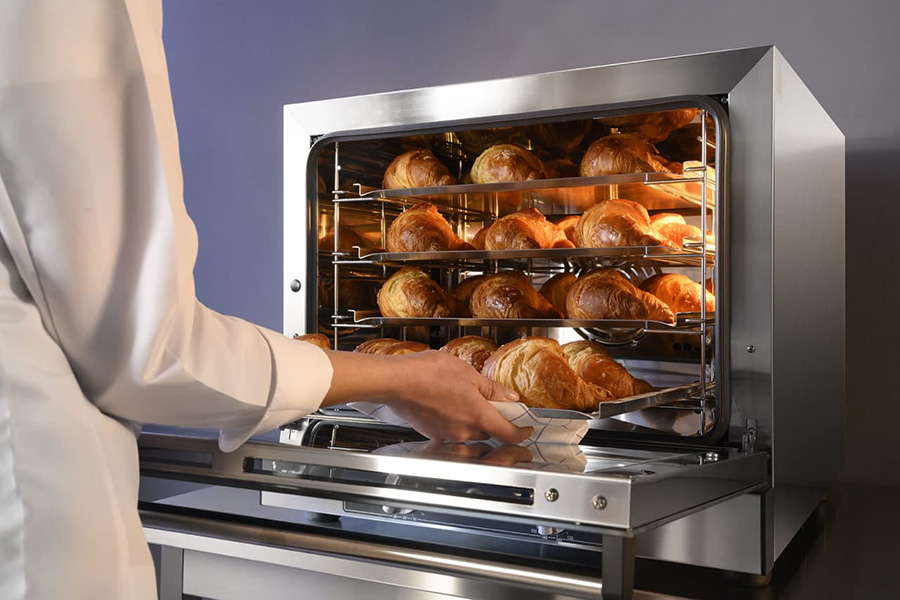 Пекар готує круасани в сучасній духовці