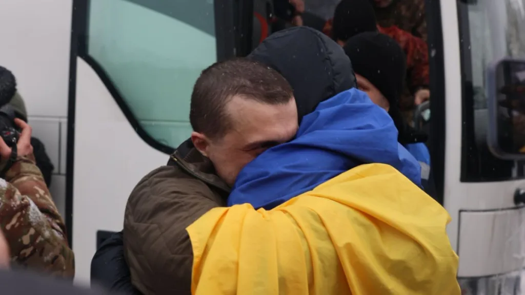 Двоє людей обіймаються, загорнуті в український прапор