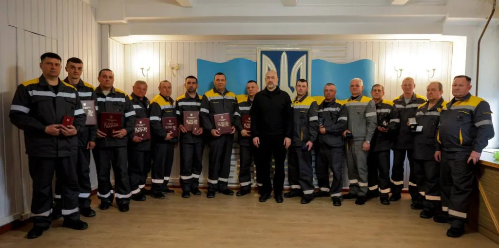 Працівники отримують нагороди перед українським прапором