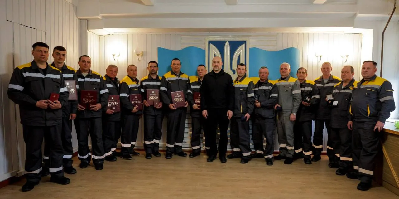 Працівники отримують нагороди перед українським прапором