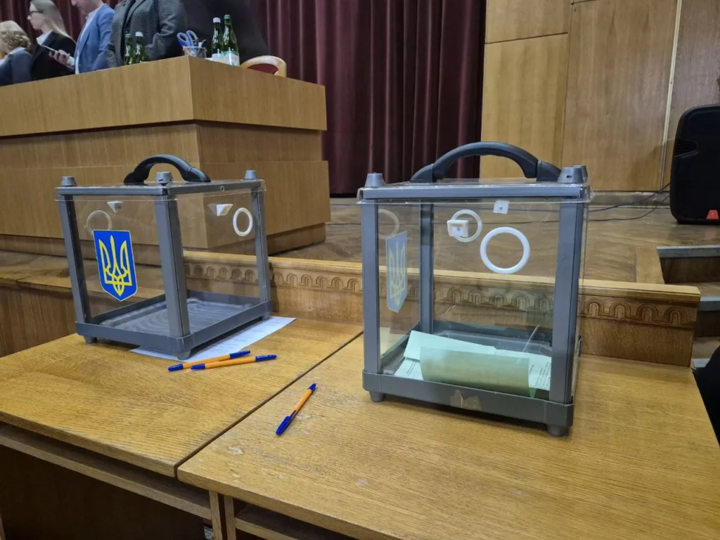 Виборчі урни з емблемою України на столі