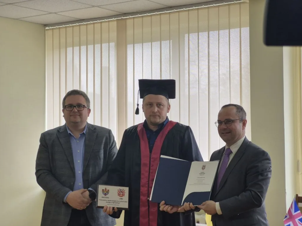 Вручення диплома випускнику в академічній мантії