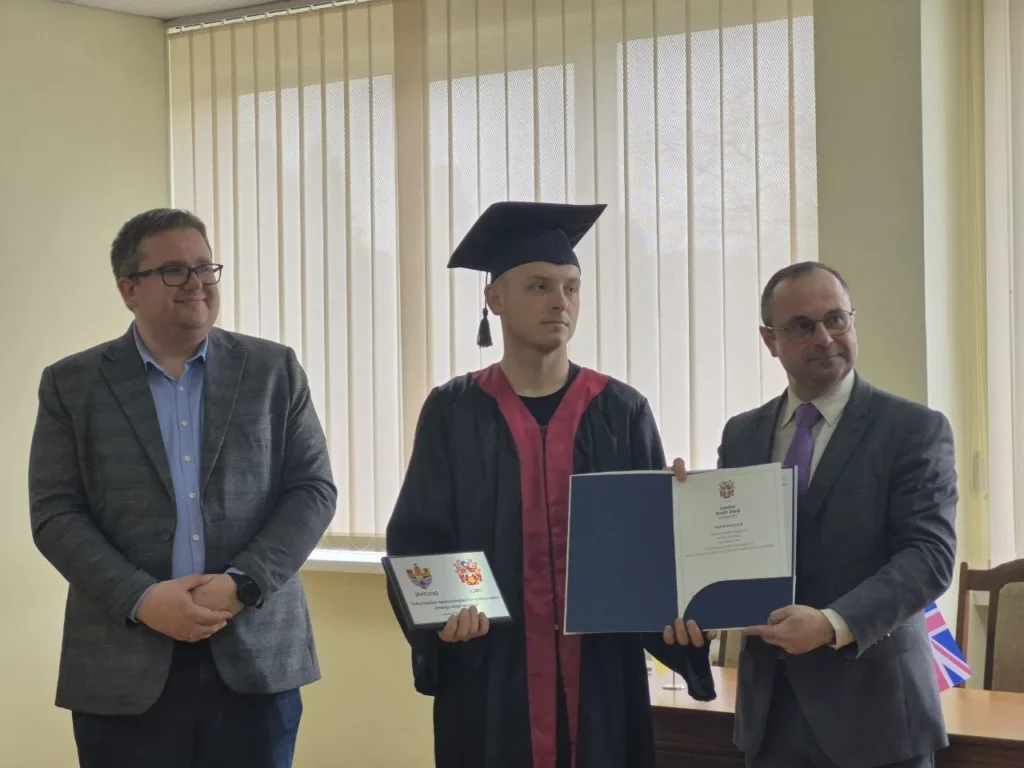 Вручення диплома випускнику у академічній мантії