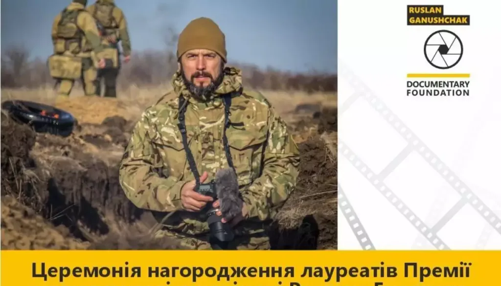 Фотограф у військовій формі з камерою на полі