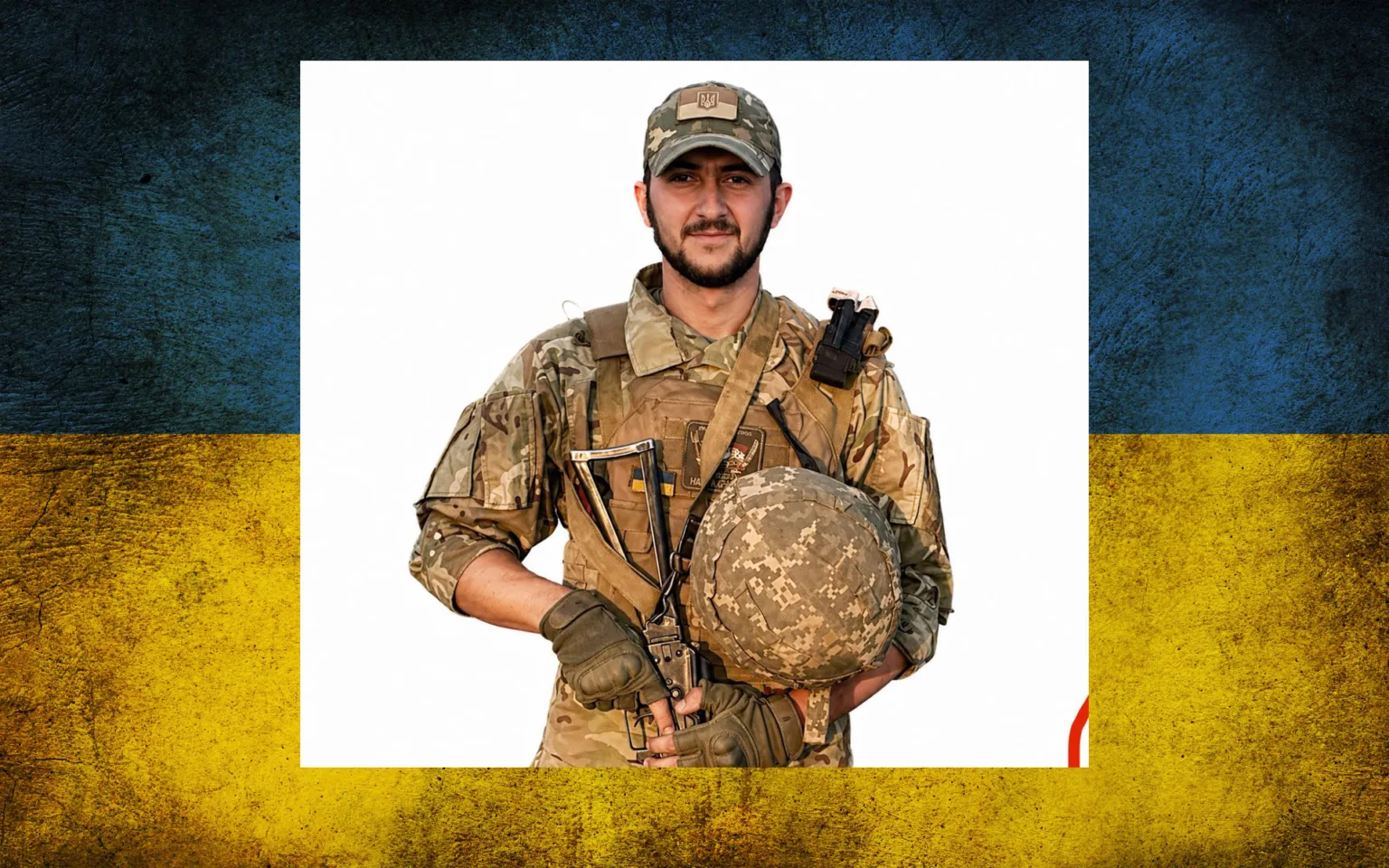 Український військовий у формі перед прапором України