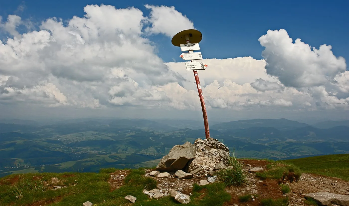 Гірський покажчик на вершині серед хмар