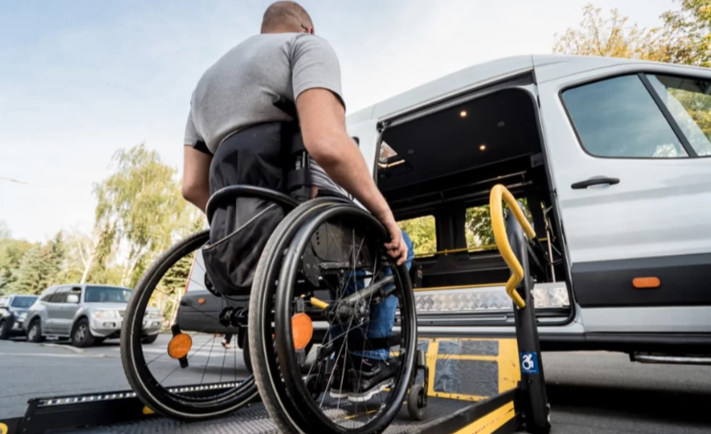 Людина на візку користується підйомником у мікроавтобус