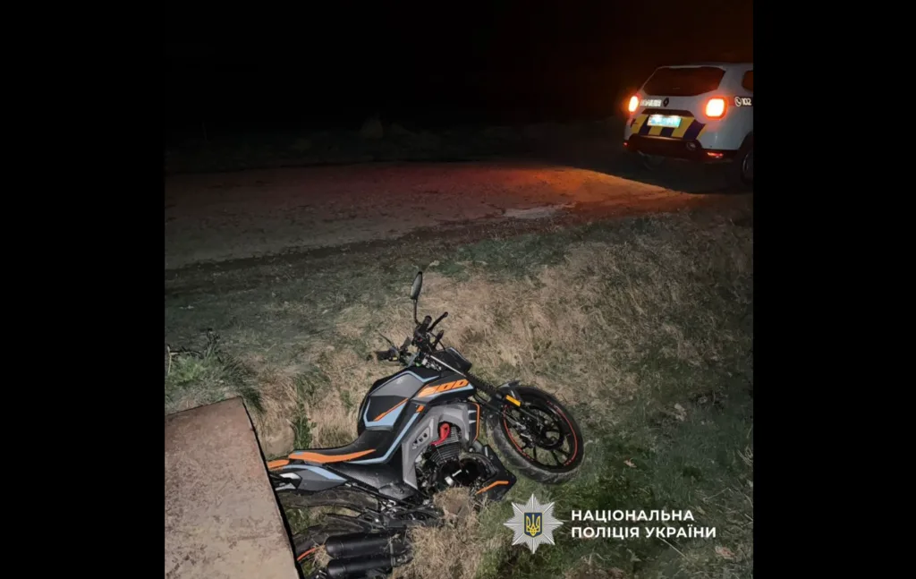 Мотоцикл після ДТП поруч із поліцейським авто