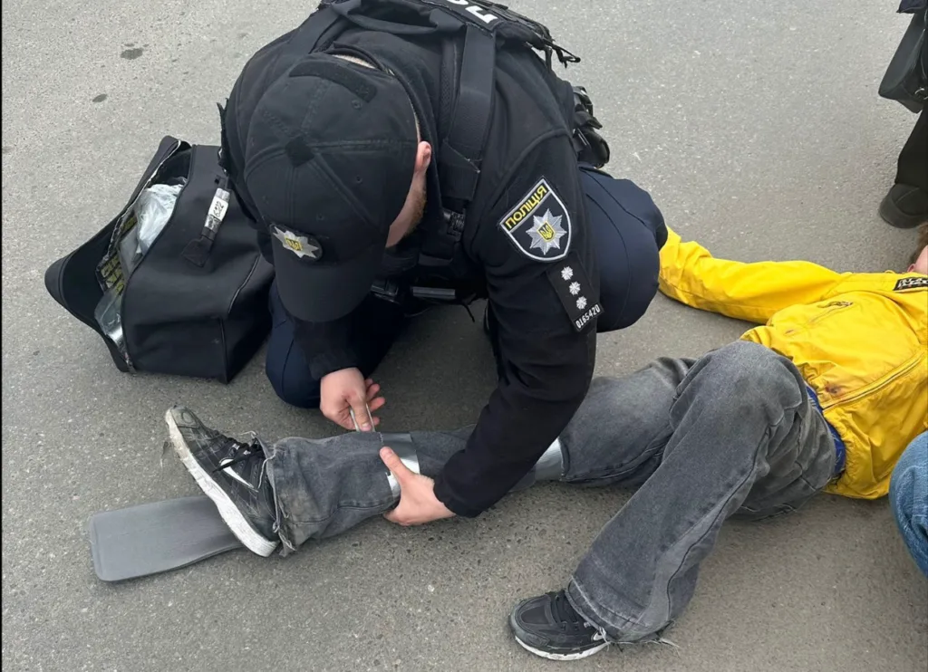 Поліцейський надає першу допомогу постраждалому на вулиці