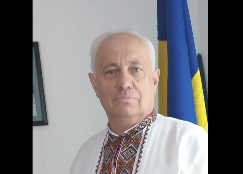 Чоловік у вишиванці перед прапором України