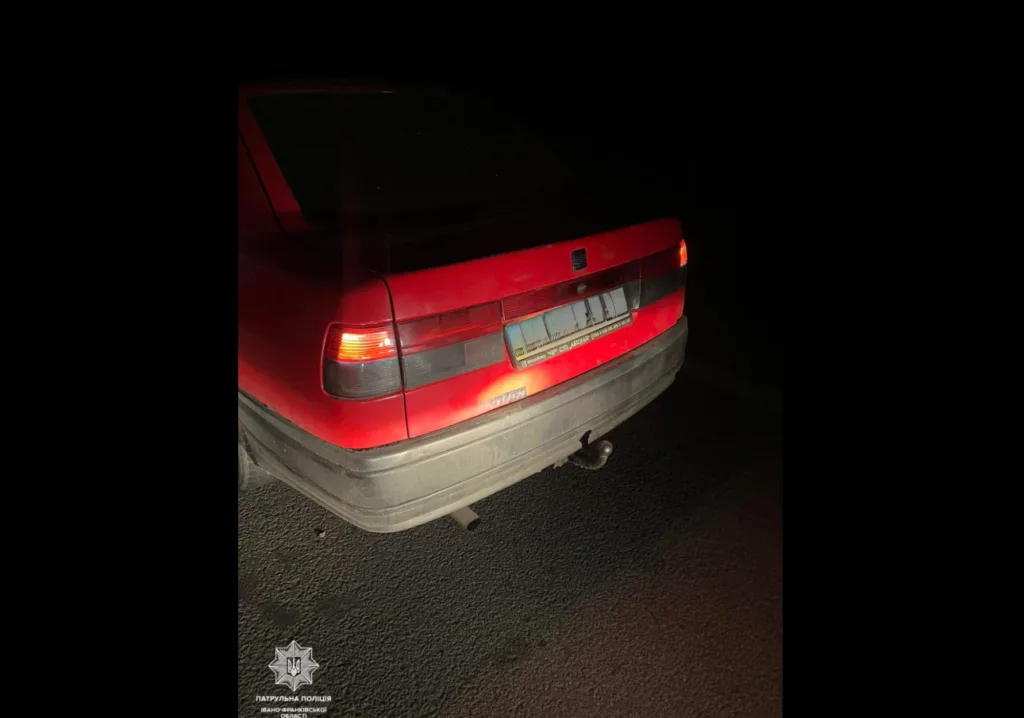 Червоний автомобіль на дорозі вночі