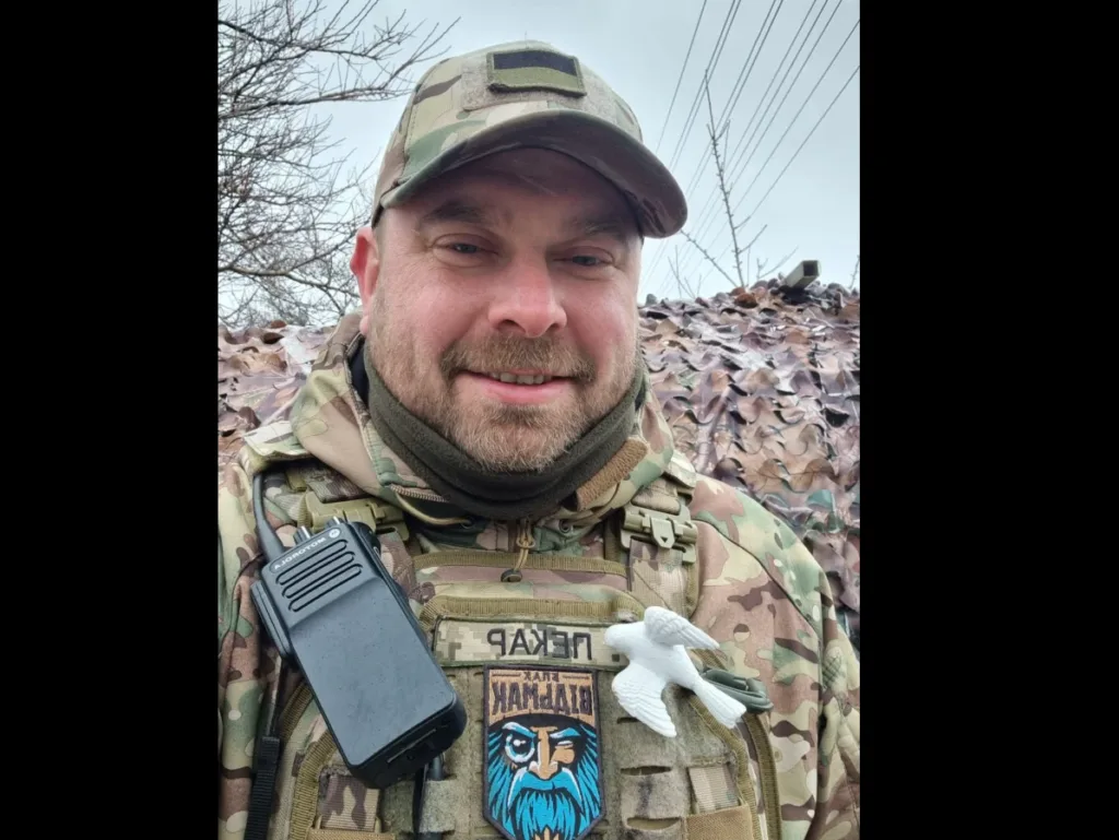 Військовий у камуфляжі посміхається на вулиці