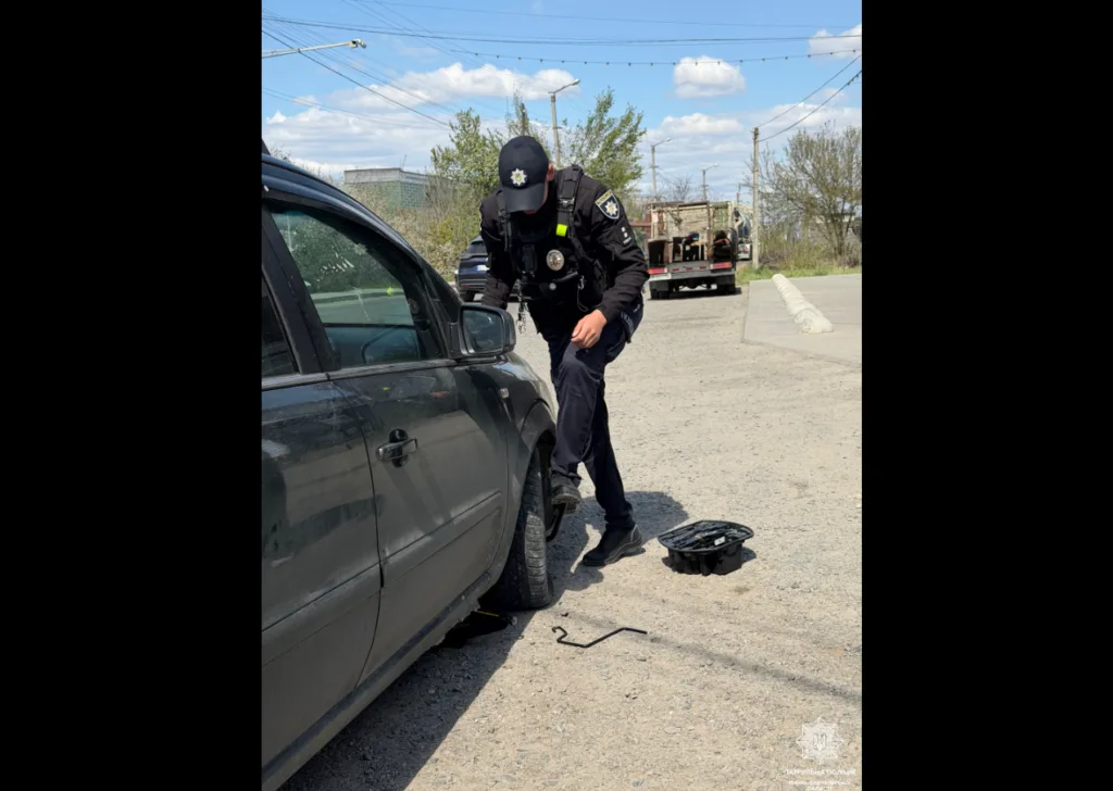 Поліцейський допомагає замінити колесо автомобіля