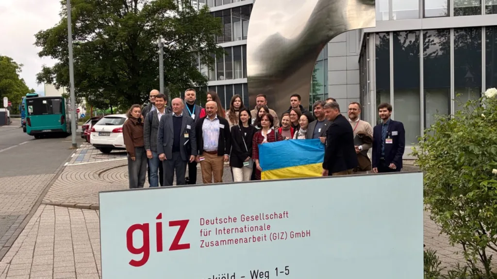Група людей з українським прапором біля офісу GIZ