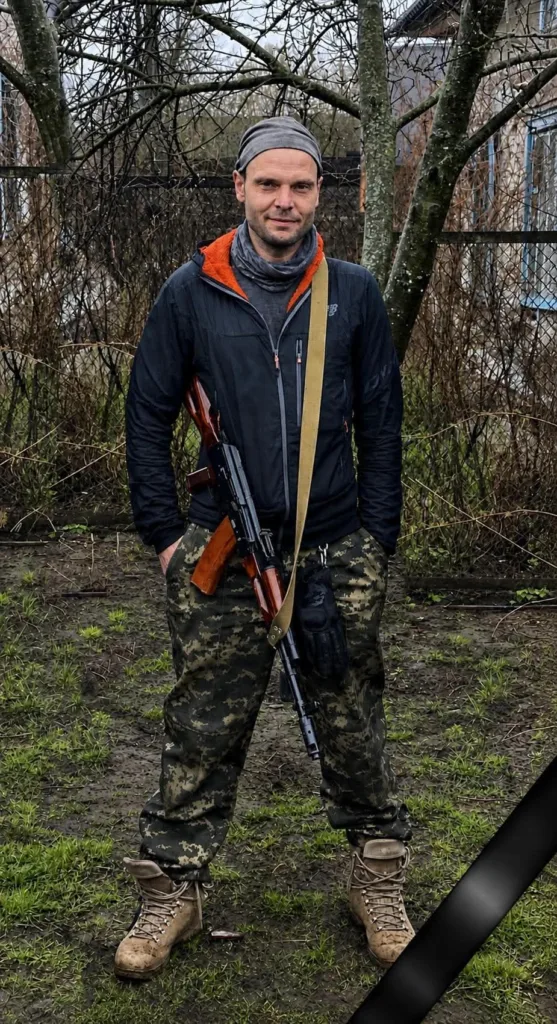 Військовий у камуфляжі стоїть на подвір’ї
