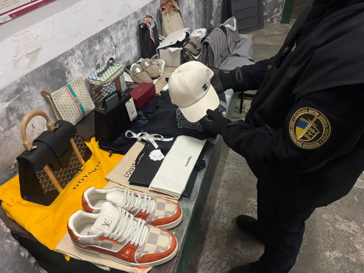 Митник перевіряє підроблені брендові аксесуари
