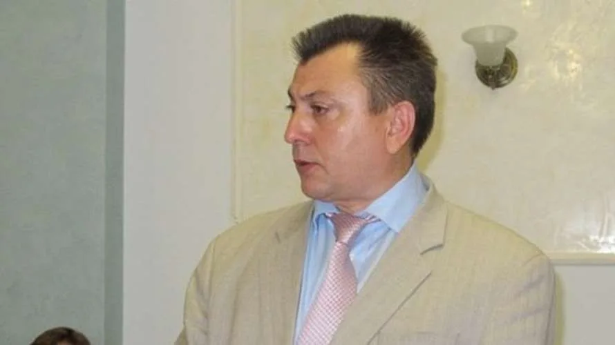 Чоловік у світлому костюмі говорить у приміщенні