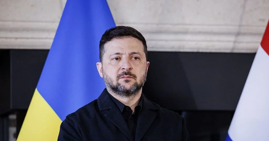 Чоловік стоїть перед українським прапором