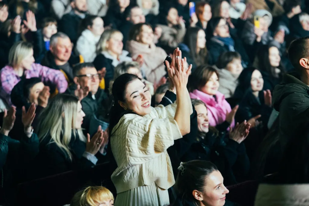Глядачі аплодують під час виступу в залі